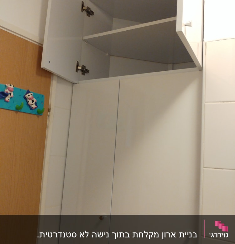 ארון קיר לבן עם דלת פתוחה ומדף פנימי